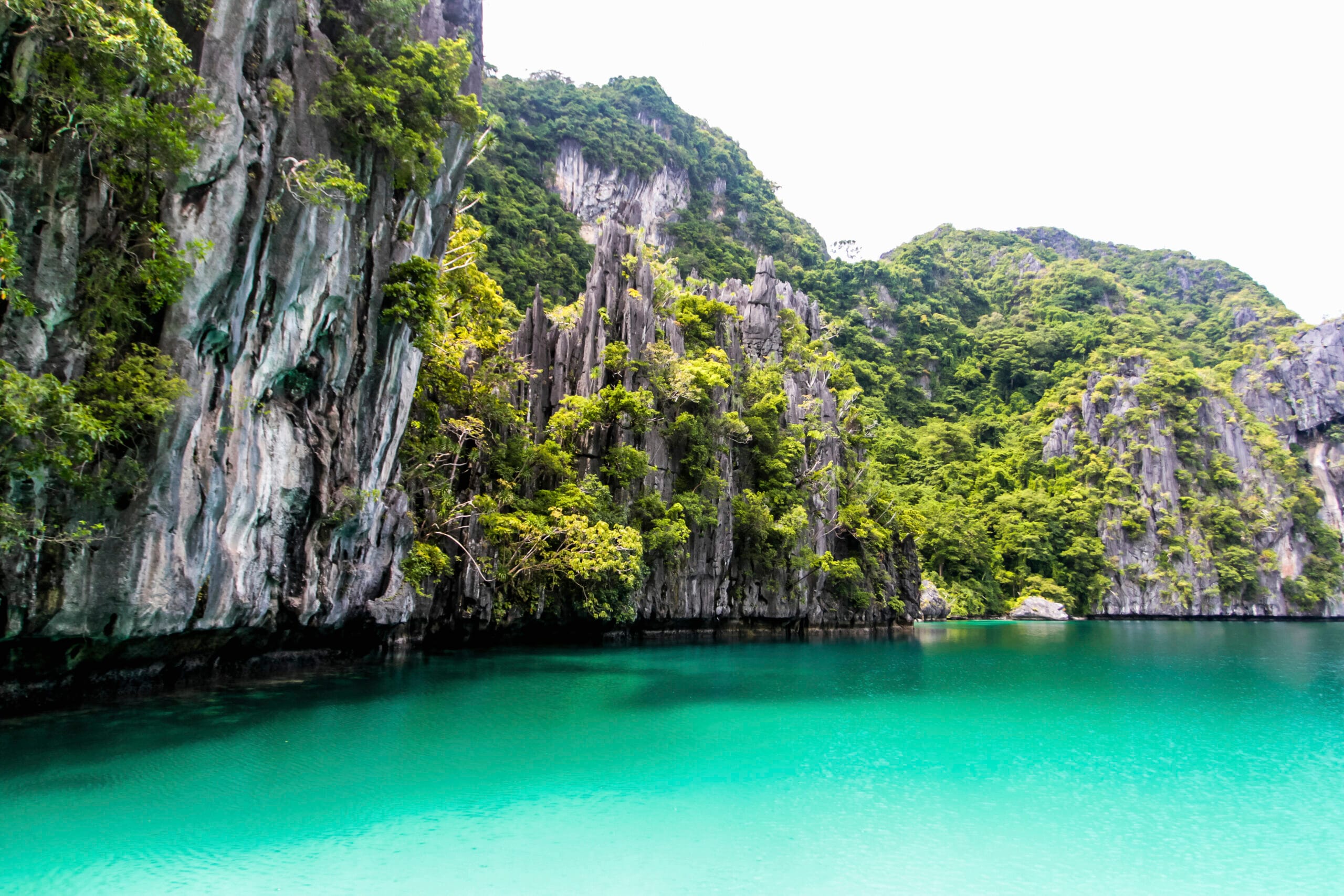 Secluded lagoon surrounded by beaches and high limestone cliffs near El Nido, Palawan, Philippines